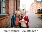 Two senior tourist female friends exploring city on vacation