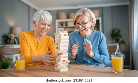 two senior women female woman friends or family sisters play leisure board game at home have fun pensioner grandmother spend time together with their mature daughter - Shutterstock ID 2318945521