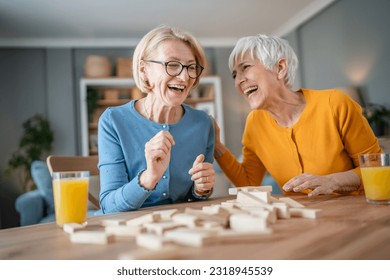 two senior women female woman friends or family sisters play leisure board game at home have fun pensioner grandmother spend time together with their mature daughter - Powered by Shutterstock