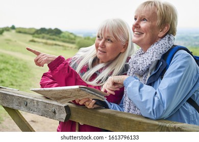 Two Senior Women Friends On Walking Holiday Resting On Gate With Map    - Powered by Shutterstock