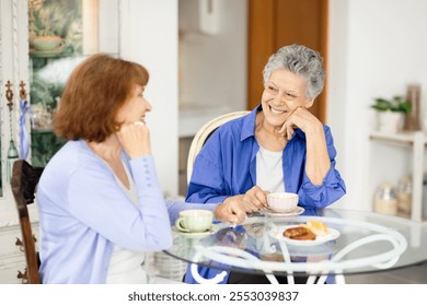 Two senior women share a joyful conversation over tea in a charming cafe. They enjoy pastries while relaxing in a warm and inviting atmosphere, showcasing their vibrant lifestyle. - Powered by Shutterstock