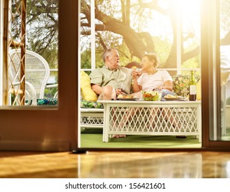 Two Seniors Having Dinner On Patio.