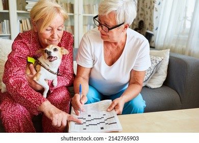 Two seniors solving crossword puzzles as brain jogging against Alzheimer's in assisted living - Powered by Shutterstock