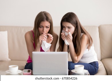 Two Sentimental Women Friends Upset Crying And Wiping Tears With Handkerchiefs While Watching Dramatic, Sad Movie, TV Reality Show Or Touching Old Home Video On Laptop While Sitting On Sofa At Home 