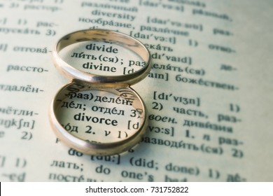Two separate wedding rings next to the word "divorce". The concept of divorce, parting, infidelity . Selective focus.