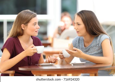 Two Serious Friends Talking Sitting In A Restaurant