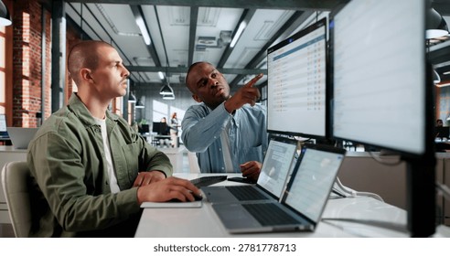 Two IT Service Managers Use Laptops Together Solving Incident Tickets Efficiently.