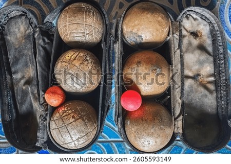 Two set of old rusty Petanque sports equipment in old small bag. Old petanque six balls and small wood jack. Bag with set of balls for petanque game. Rusty balls in boules for competition or as hobby.