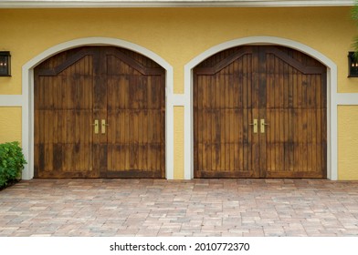 Two Sets Of Wooden Garage Doors On Exterior Of Building.