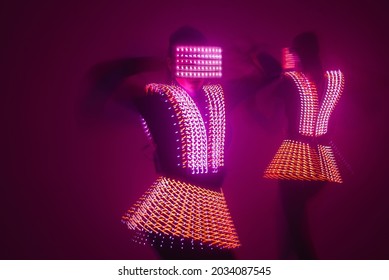 Two sexy disco dancers move in UV costumes. Parties and dances.