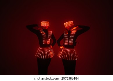 Two sexy disco dancers move in UV costumes. Parties and dances.