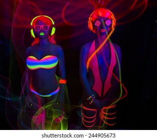 two sexy female disco dancers posing in UV costume