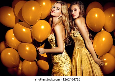 Two sexy girls in golden balloons. Celebrating.