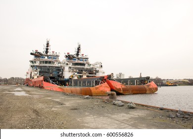 Two ship together in a row working hard with a man cleaning on board