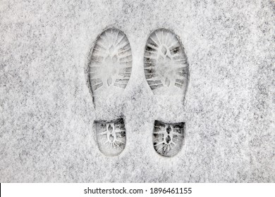 Two Shoe Prints Side By Side In Fresh Snow On The Sidewalk.