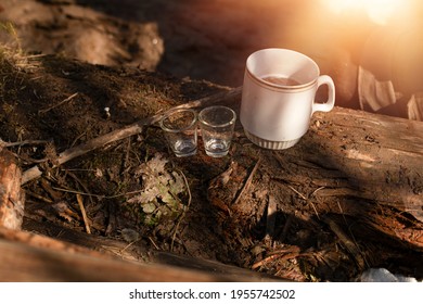 Two Shot Glasses And Mug Lying On Timber Log.