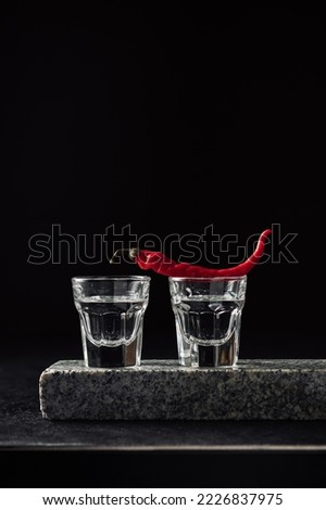 Two shots of vodka with red hot pepper.