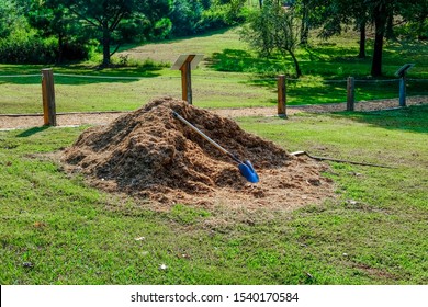 Two Shovels By Mulch Pile In Park