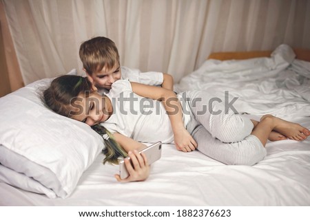 Similar – Little girl playing with boy over the bed