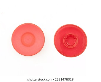 Two sides of red plastic bottle cap isolated on white background. Round cosmetics tube lid