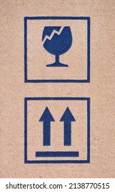 Two Signs On Cardboard Box - Fragile And This Way Up. Close-up.