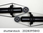 Two silent blocks on new shock absorbers, parts for car repair. A set of spare parts for servicing the chassis of the vehicle. Details on white background, copy space available.