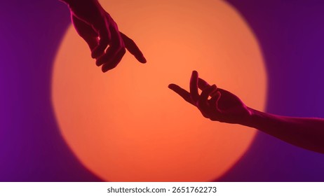 Two silhouetted hands are captured in a dramatic pose with a vibrant orange and purple gradient background.