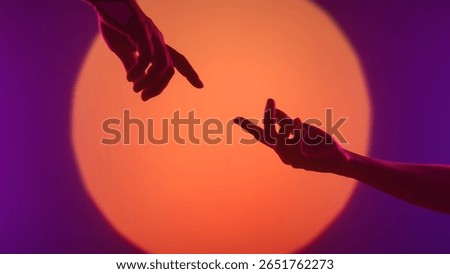 Two silhouetted hands are captured in a dramatic pose with a vibrant orange and purple gradient background.