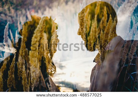 Two silhouettes seen against the background of wheat