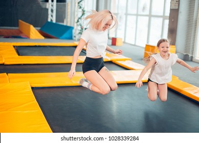 Two Sisters Bouncing In The Trampoline Park