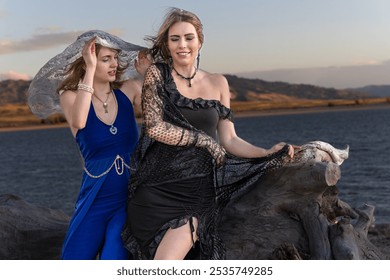 Two sisters cosplaying as Samhain goddesses on a beach, adorned with floral crowns and flowing attire. Set against a coastal backdrop, perfect for themes of fantasy, mythology, and mystical beauty. - Powered by Shutterstock