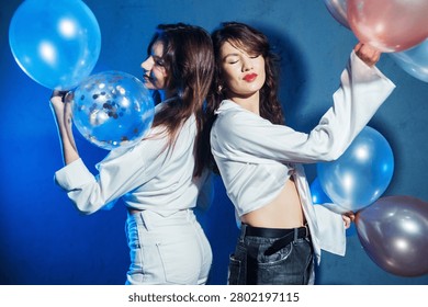 Two sisters are having fun and dancing at a balloon party. The concept is about fashion, beauty, and fun.