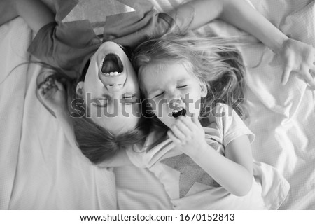 Similar – Little girl playing over boy lying in the bed