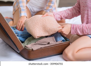 Two sisters are packing baggage.