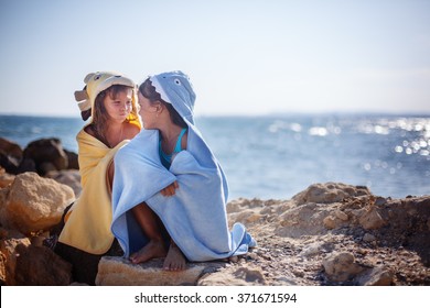 Two Sisters Playing On The Beach, Beach Towels , Sea, Sun, Warmth And Comfort .