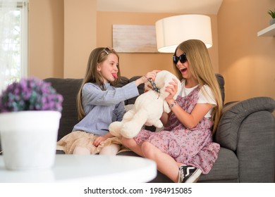 Two Sisters Are Playing With The Stuffed Bunny Toy In The Living Room.