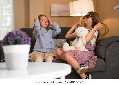 Two Sisters Are Playing With The Stuffed Bunny Toy In The Living Room.