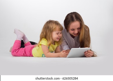 Two Sisters Playing Or Working With IPad Over Isolated White Background