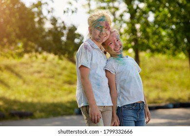 Two sisters smeared with paint pose for the camera outdoors in a Sunny Park. Selective focus - Shutterstock ID 1799332666