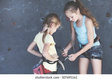 Two Sisters Standing Near A Rock Wall For Climbing Indoor