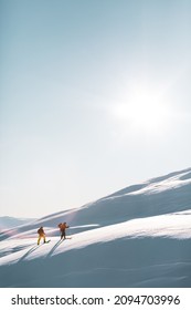 Two Skiers Scaling The Mountain