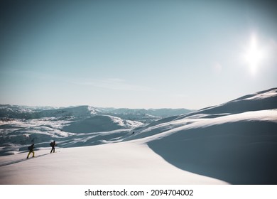 Two Skiers Scaling The Mountain