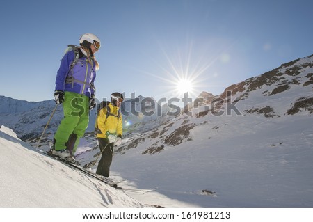 two skiiers watch the departure