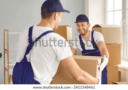 Two skilled man movers, staff of a relocation company, work during a home or office move. With precision and teamwork, they handle cardboard boxes, ensuring the safe delivery of belongings.