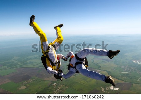 Two skydiver in freefall in the clouds.
