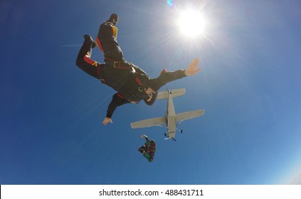 Two skydivers jump from an airplane 