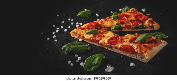 Two Slice Of Flatbread Pizza With Mozzarella Cheese, Tomatoes, Pepper, Spices And Fresh Basil. Italian Pizza. Pizza Margherita Or Margarita  On Dark Grey Black Slate Background