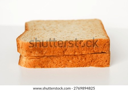 Two slices of bread stacked on top of each other, showing their soft texture and crust.