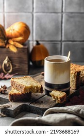 Two Slices Of Pumpkin Bread On Wooden Board With Glass Of Tea And Pumpkins On Background. Autumn Dessert, Text Space. Vertical Orientation