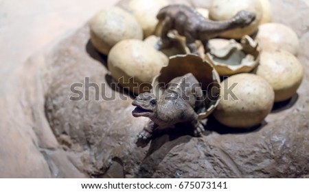 Two small dinosaur just born and many eggs in the cave.